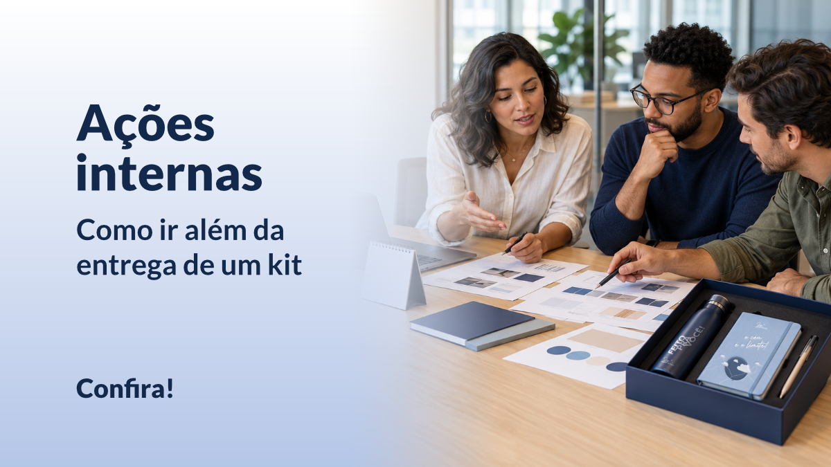 Equipe planeja uma ação interna para colaboradores com materiais de comunicação e um kit corporativo sobre a mesa.