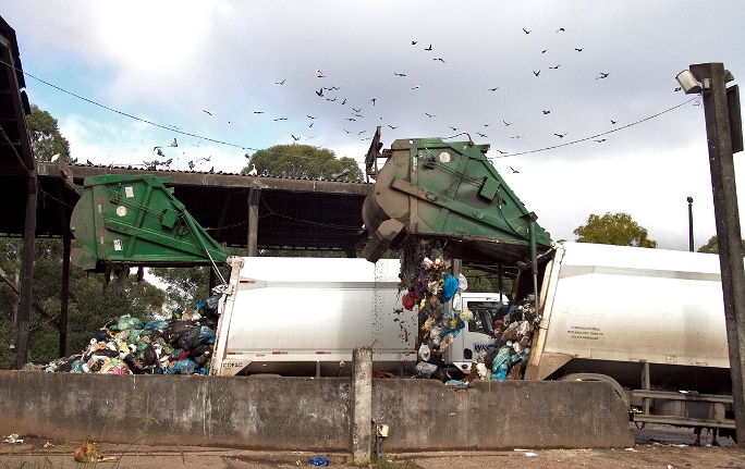 Momento em que caminhões descarregam os resíduos diversos
