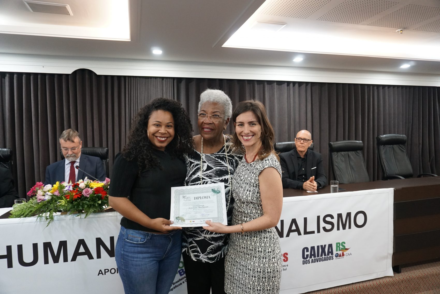Naira Hofmeister e Thayse Uchôa receberam o prêmio das mãos de Vera Deisy Barcellos, presidente de Sindicato dos Jornalistas